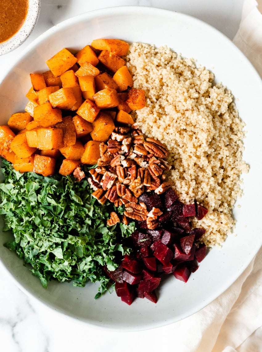 bowl of beet quinoa salad with butternut squash, kale, and pecans