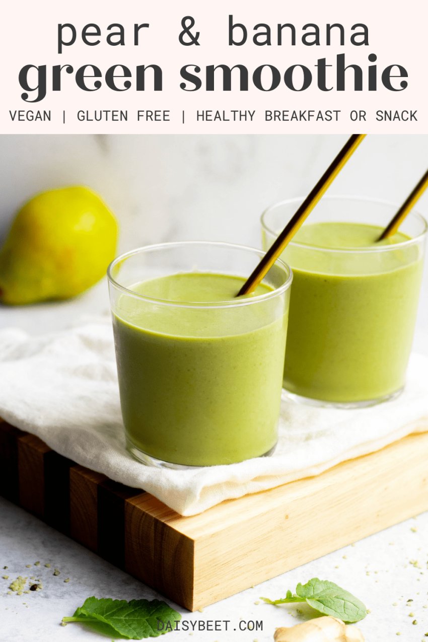 Two glasses of pear banana green smoothie with gold straws sitting on a wooden cutting board