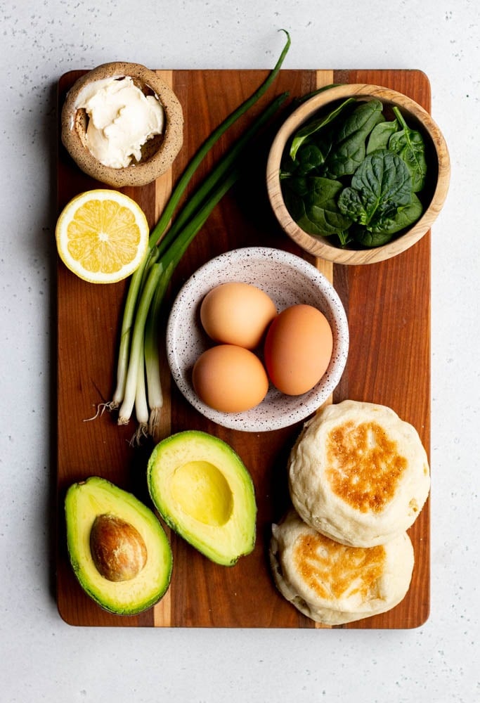 Avocado egg sandwich ingredients measured out on wooden cutting board