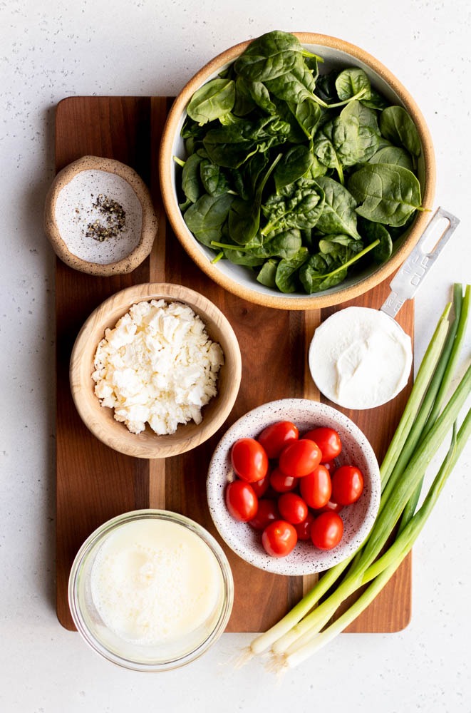 Ingredients for egg white frittata measured out on a wooden cutting board