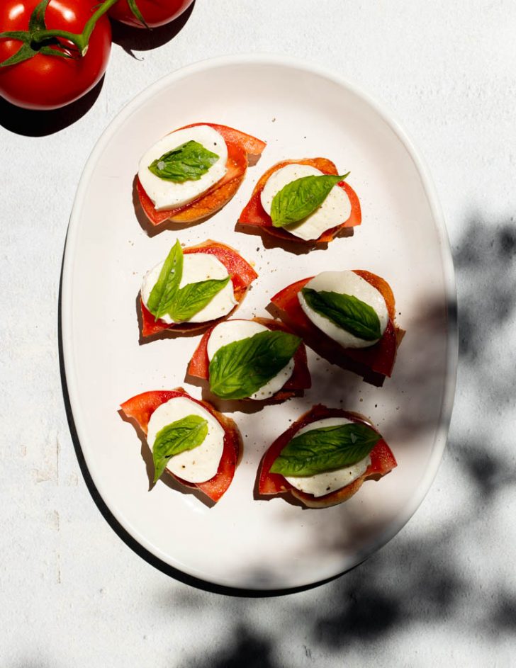 white plate of tomato basil mozzarella bruschetta