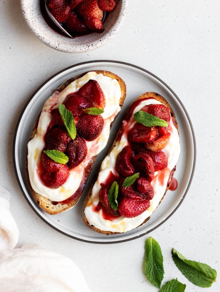plate with two pieces of ricotta and strawberry toast