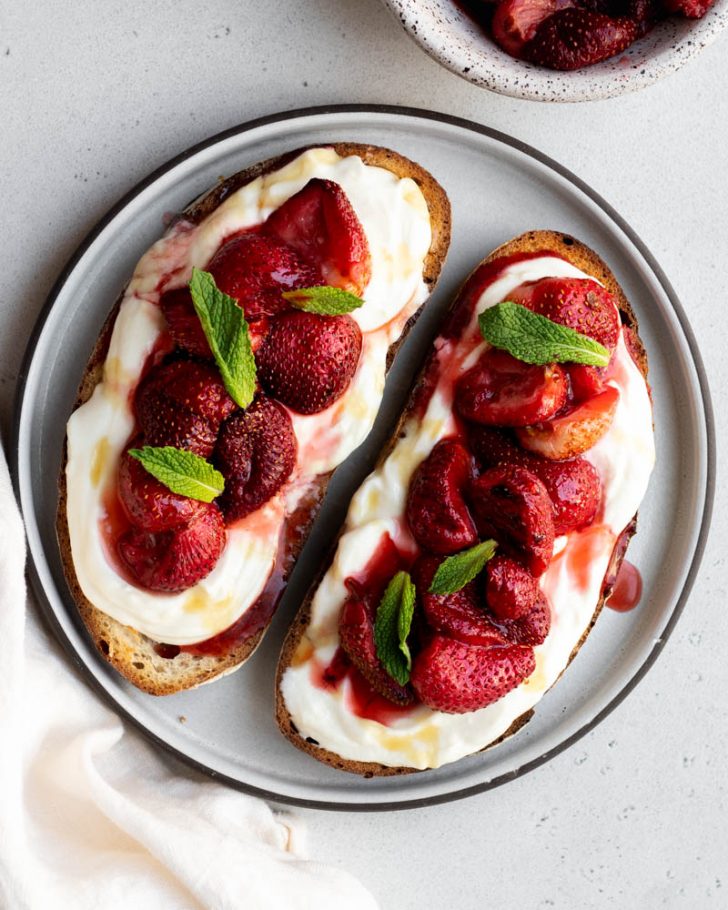 plate with two pieces of ricotta and strawberry toast