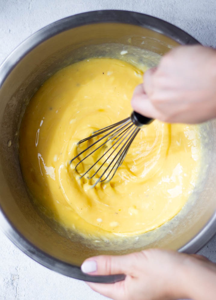 hand whisking eggs in a mixing bowl