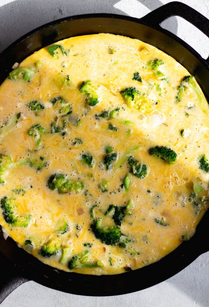 Broccoli frittata in a cast iron skillet before being cooked 