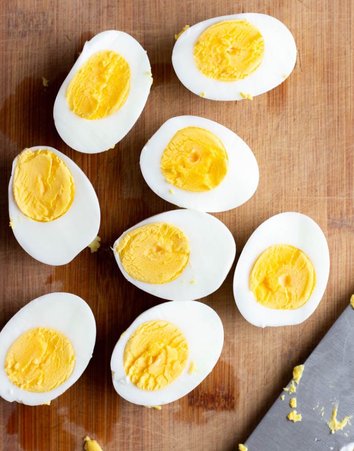 Hard boiled eggs cut in half on a wooden cutting board