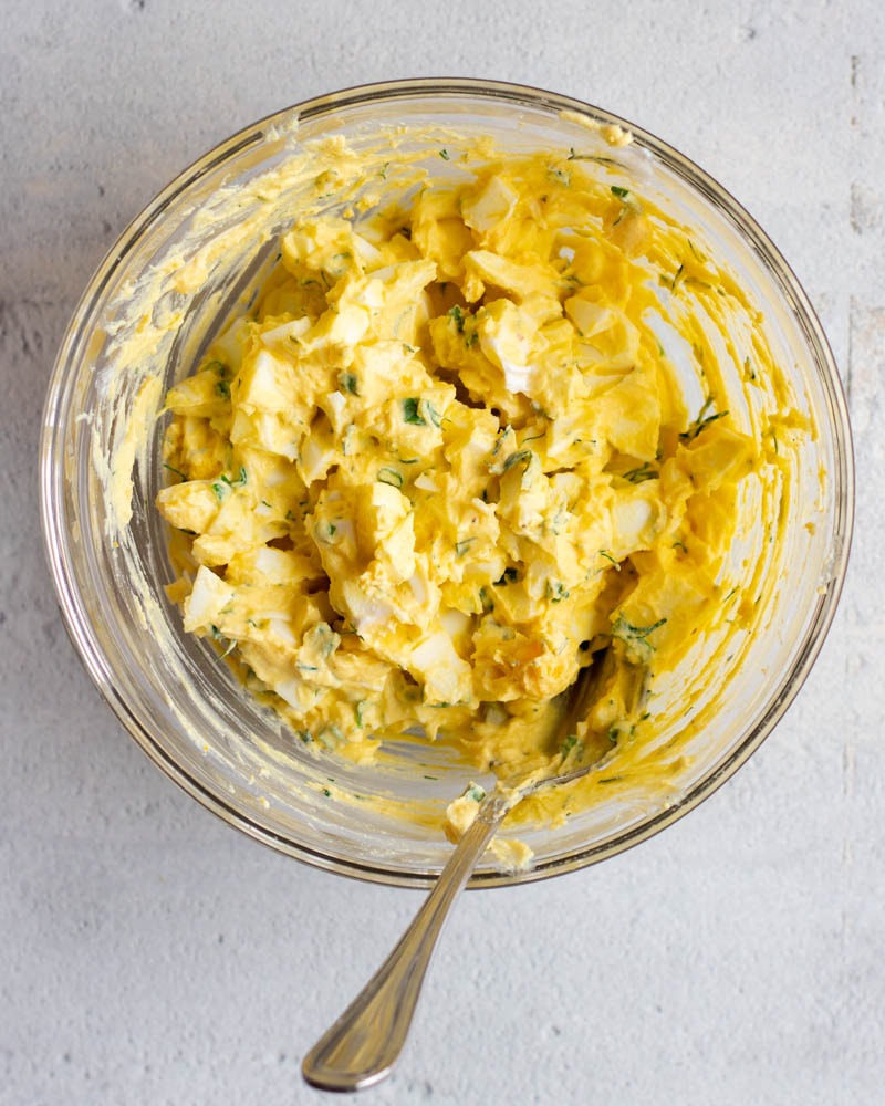 Creamy egg salad in a glass mixing bowl