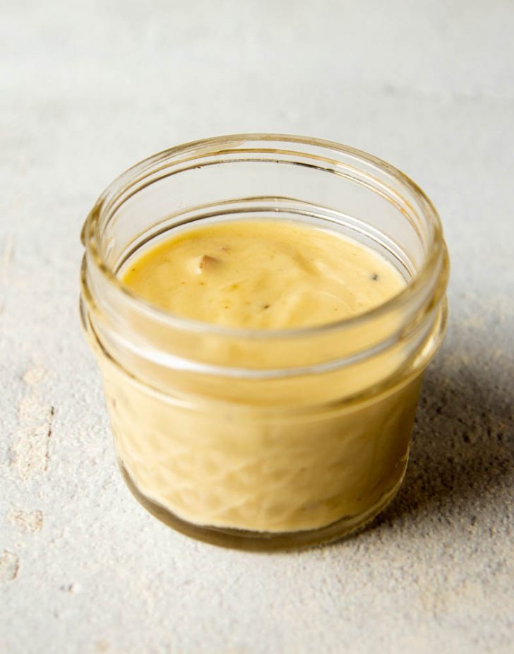 small jar of creamy tahini apple cider salad dressing