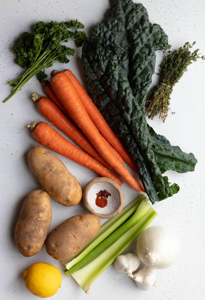 carrot potato soup ingredients measured out on a grey backdrop