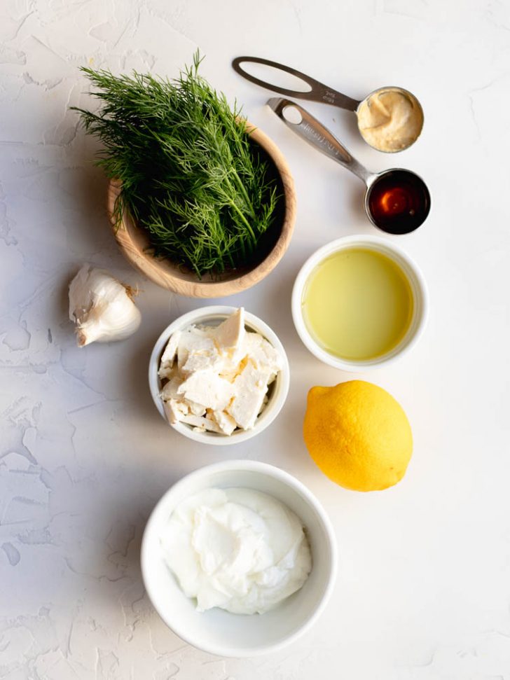 feta dill Greek yogurt salad dressing ingredients measured out on a white backdrop