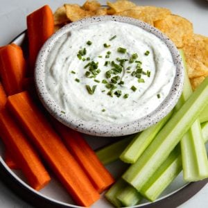 plate of Greek yogurt ranch dip with veggie sticks and potato chips