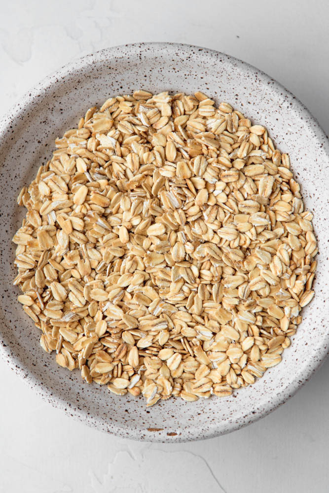 white speckled bowl filled with old fashioned oats