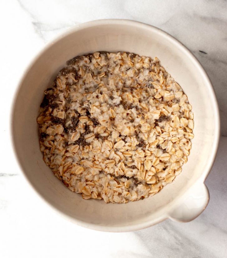 cooked oatmeal in a bowl on a marble backdrop