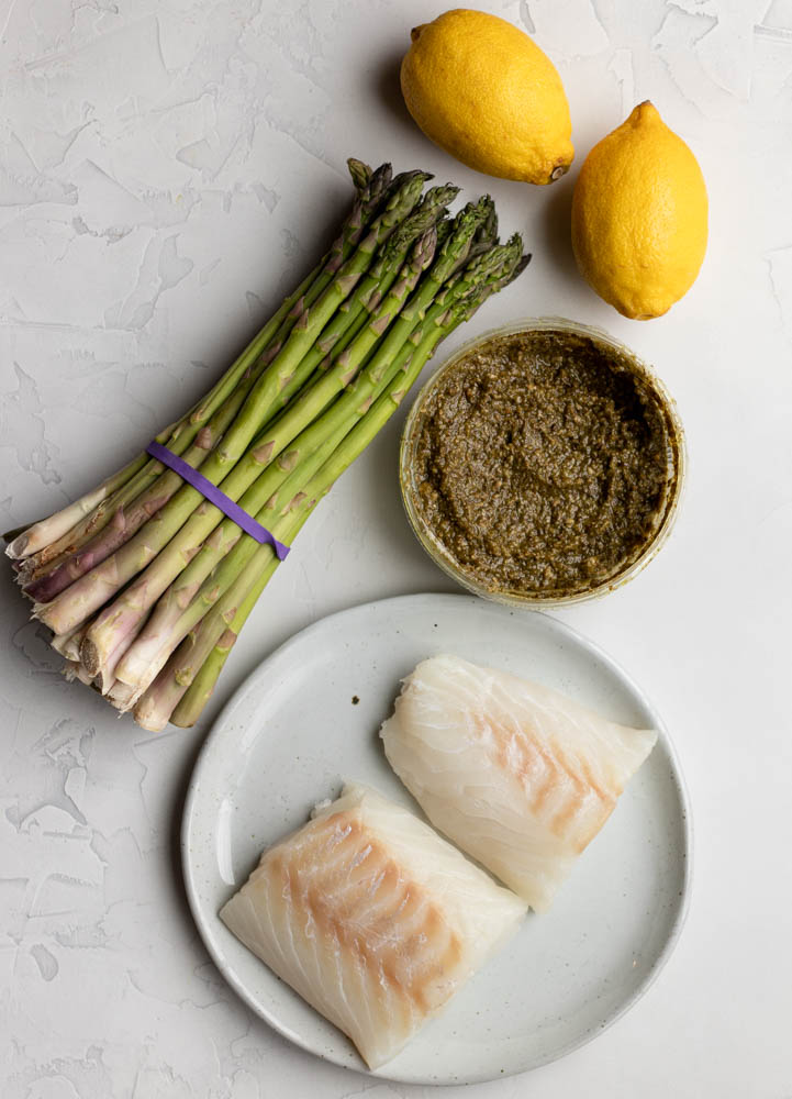 pesto baked cod in foil ingredients displayed on a light grey backdrop