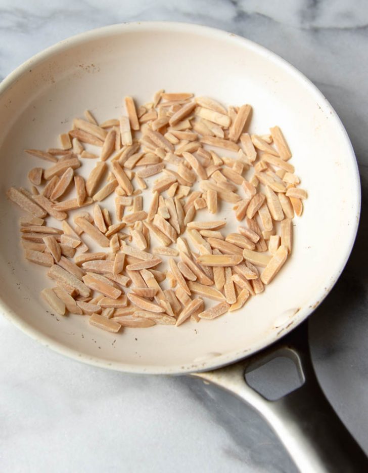 Slivered almonds toasted in a white skillet