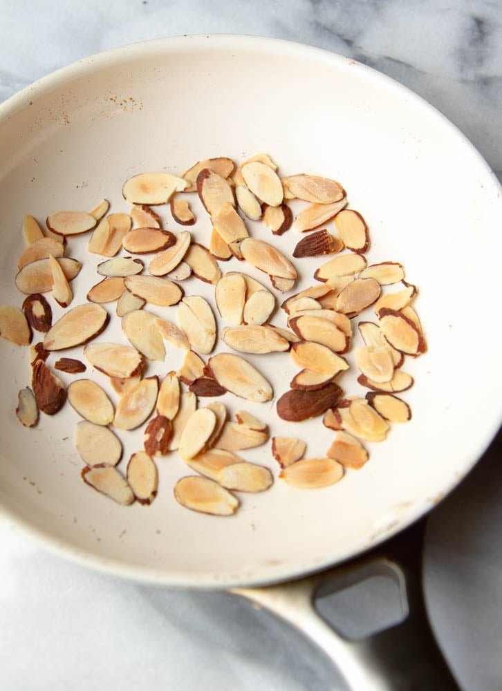 Sliced almonds toasted in a white skillet