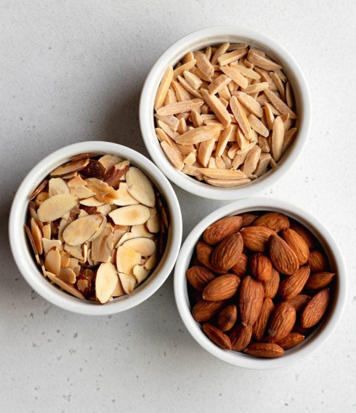 three small ramekin filled with toasted whole almonds, almond slivers, and almond slices