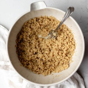 cooked quinoa in a white bowl with fork