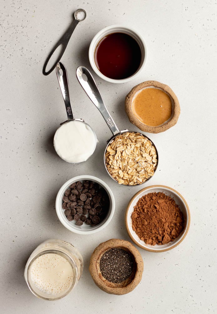 chocolate peanut butter overnight oats ingredients measured out on a light grey backdrop