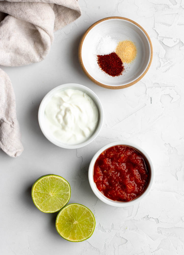 taco salad ingredients measured out on a white backdrop
