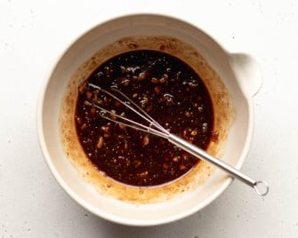 fig balsamic vinaigrette dressing in a small mixing bowl with a small silver whisk