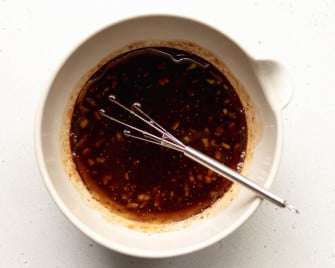 fig balsamic dressing in a small bowl with a silver mini whisk