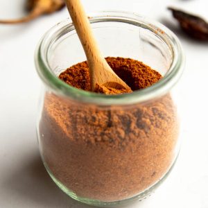 small jar of homemade chili powder with a small wooden spoon
