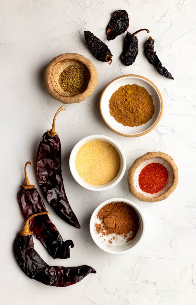 homemade chili powder ingredients measured out on a light grey backdrop