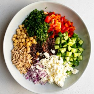 red quinoa salad ingredients in a salad bowl before being mixed