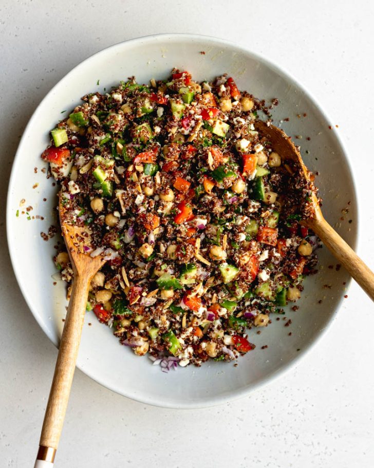 large bowl of red quinoa salad with wooden salad spoons