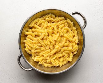 cooked rotini pasta in a metal colander