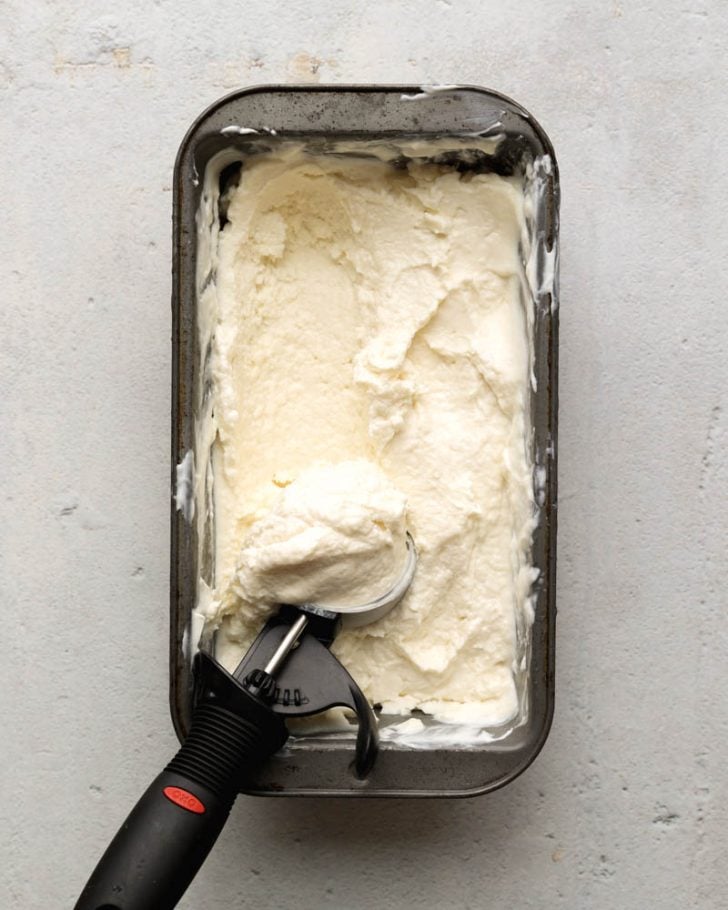 loaf pan with Greek frozen yogurt being scooped out with an ice cream scoop