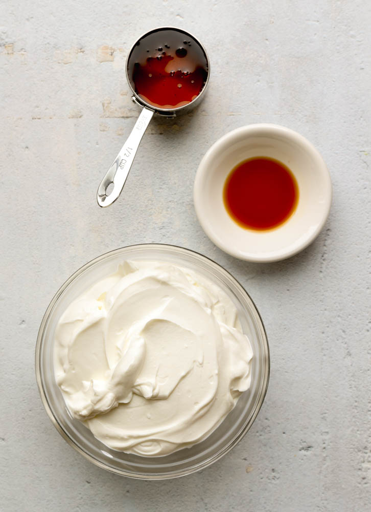 Frozen greek yogurt ingredients measured out on a light grey backdrop