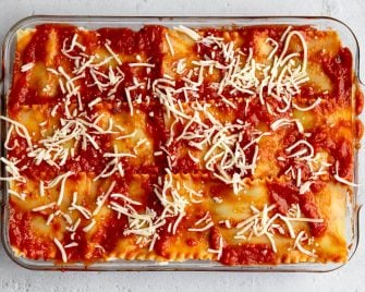 lasagna layered in a glass baking dish before being baked