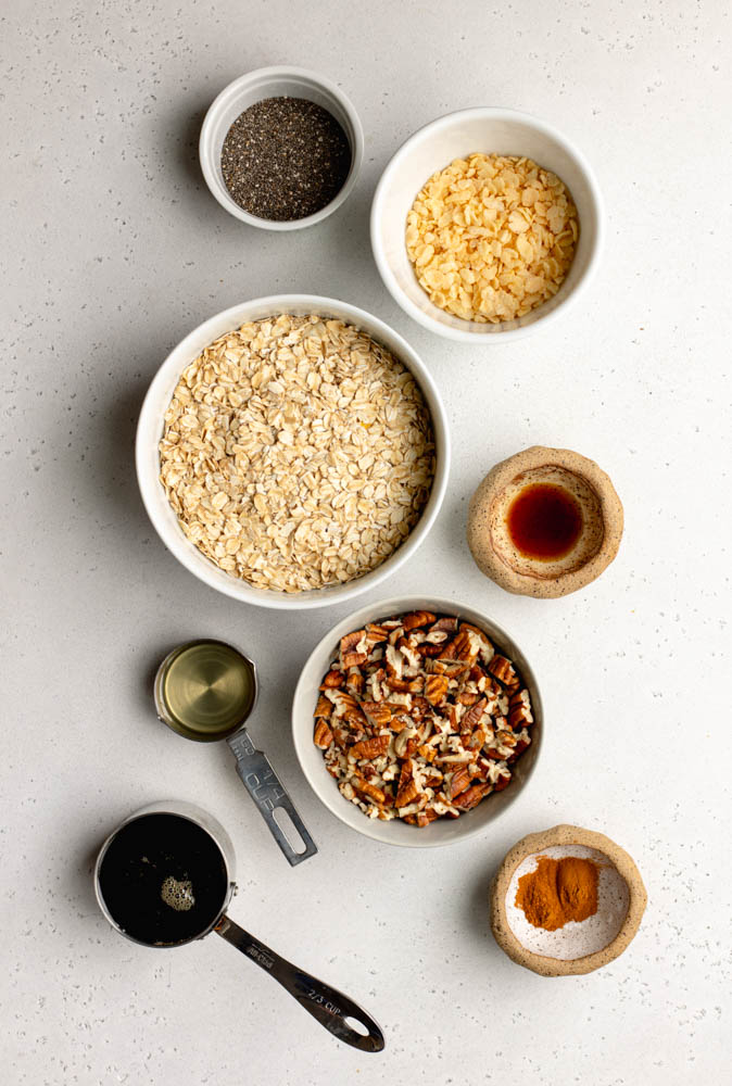 Maple pecan granola ingredients measured out on a white backdrop