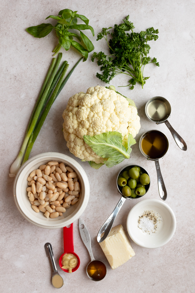 raw cauliflower salad ingredients measured out on a light background