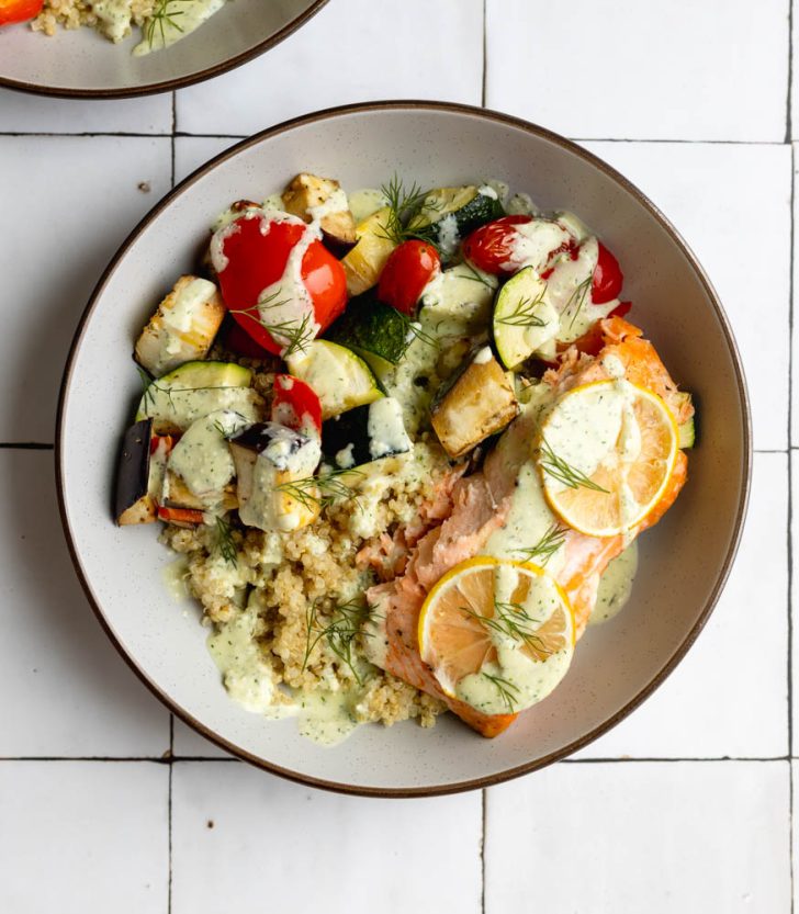 salmon quinoa bowl on a white tiled backdrop