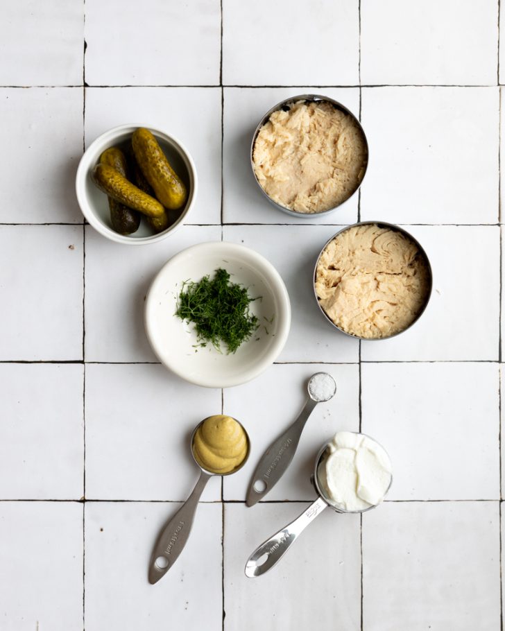 tuna salad with greek yogurt ingredients measured out on a white tiled backdrop