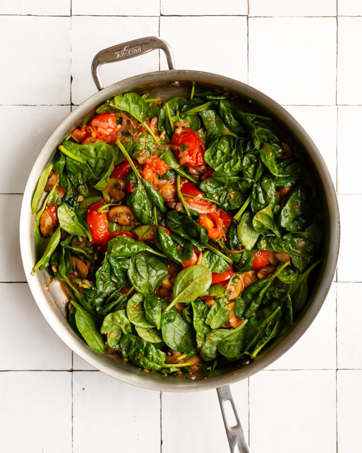 sauteed spinach, tomatoes, and mushrooms in a saute pan