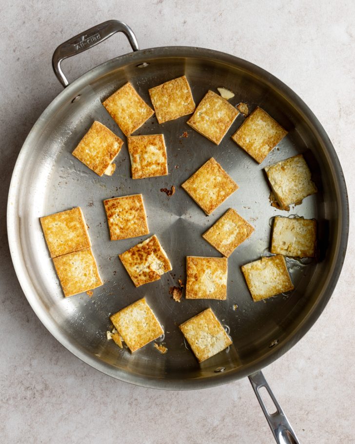 Cooked tofu squares in a saute pan