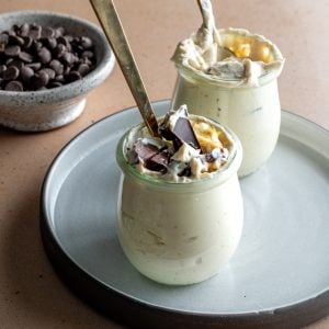 two greek yogurt peanut butter dessert cups on a plate with brass spoons