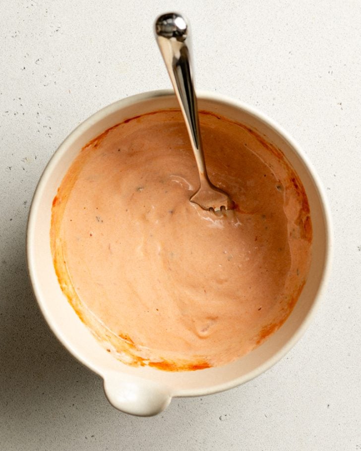 small bowl of greek yogurt mixed with tomato sauce
