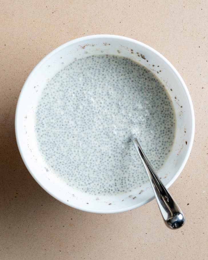 chia pudding in a white bowl with a silver spoon