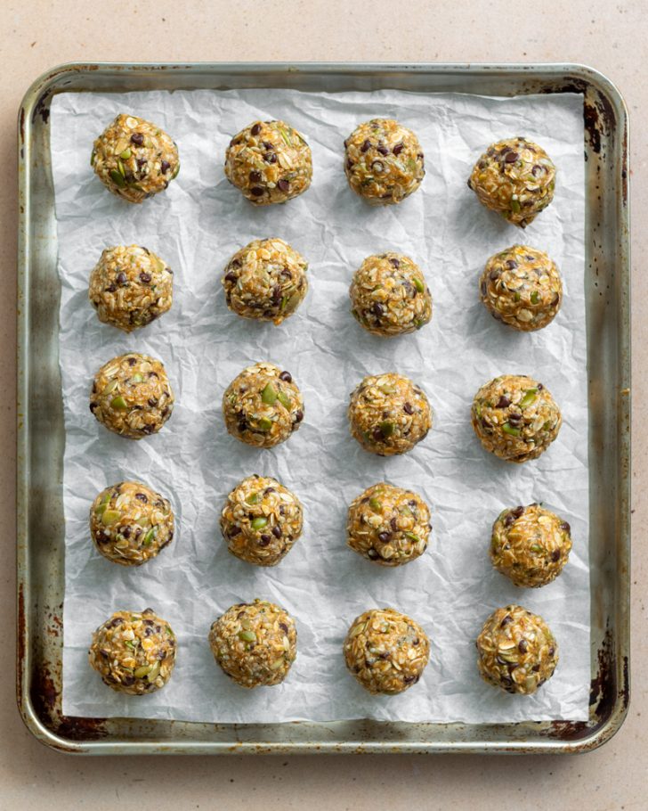 20 protein balls on a parchment paper lined baking sheet