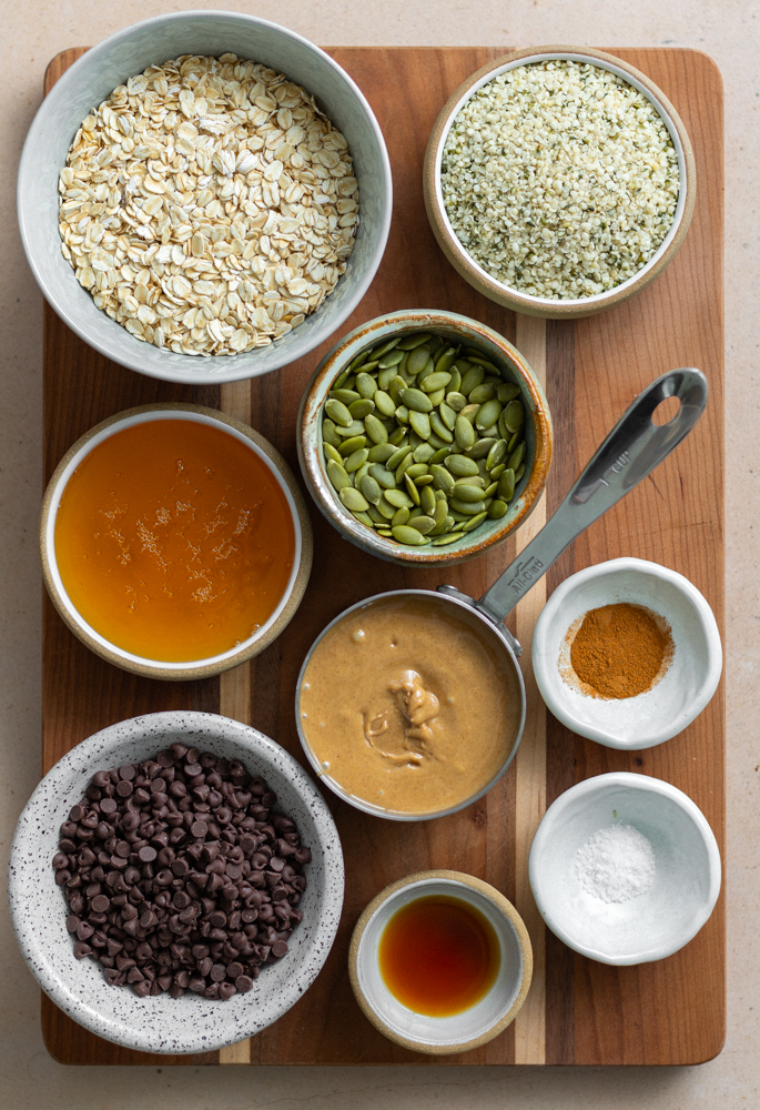 no bake protein balls ingredients measured out in little bowls on a wooden cutting board