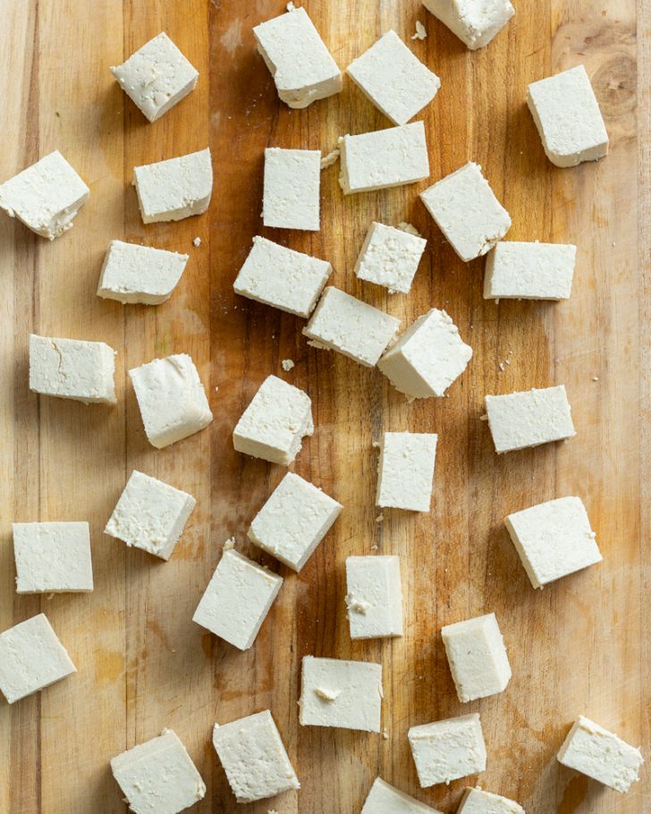 tofu cubes on wooden cutting board